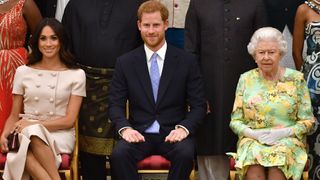 Meghan, Duchess of Sussex, Britain's Prince Harry, Duke of Sussex and Britain's Queen Elizabeth II pose for a picture during the Queen's Young Leaders Awards Ceremony on June 26, 2018 at Buckingham Palace in London.