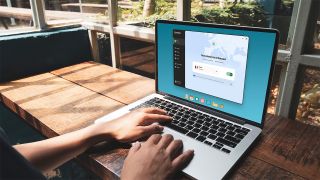 A person works on a laptop that displays Norton VPN software on the screen.