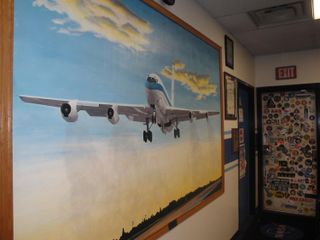 The mission briefing room at NASA's Reduced Gravity Education Flight Program at Ellington Field, Houston, is decorated with paintings of aircraft used in the weightless flights and the emblems of past missions.