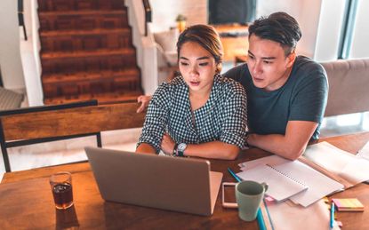 Couple at desk looking at computer