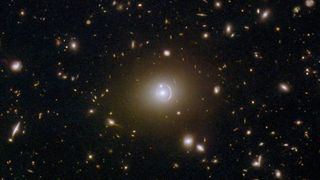 a black background speckled with bright points of light and small arcs, each being a distant galaxy 