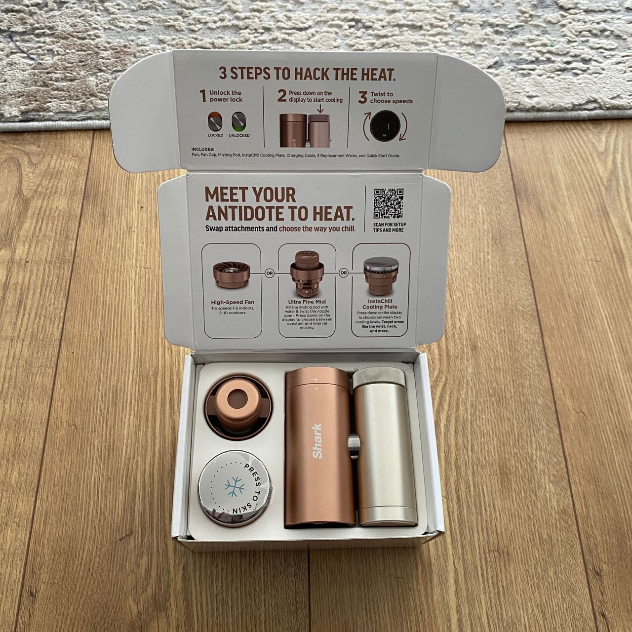 Open packaging of the Shark ChillPill on a wood look floor next to a rug