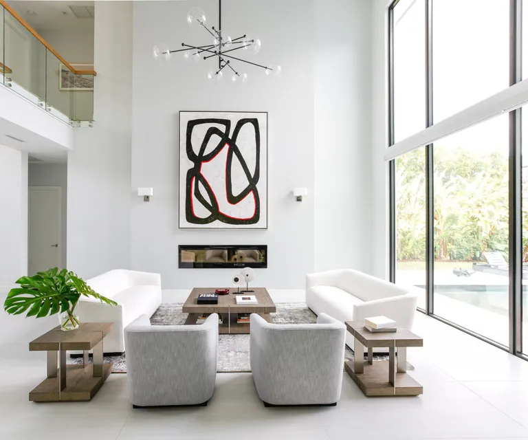 White living room with double height ceilings and windows