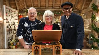 Mark Stuckey, Jo Thomas and Jay Blades (L-R) standing behind Jo's wooden record player for The Repair Shop at Christmas 2023