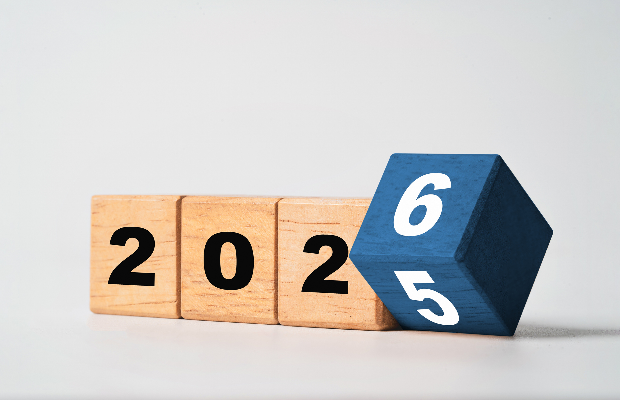 Flipping of 2025 to 2026 on a wooden block cube for new year change