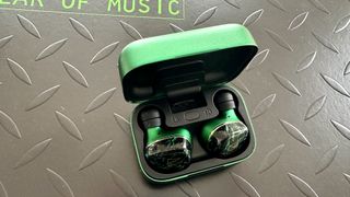 Noble FoKus Rex5 earbuds in a green case on a metallic surface