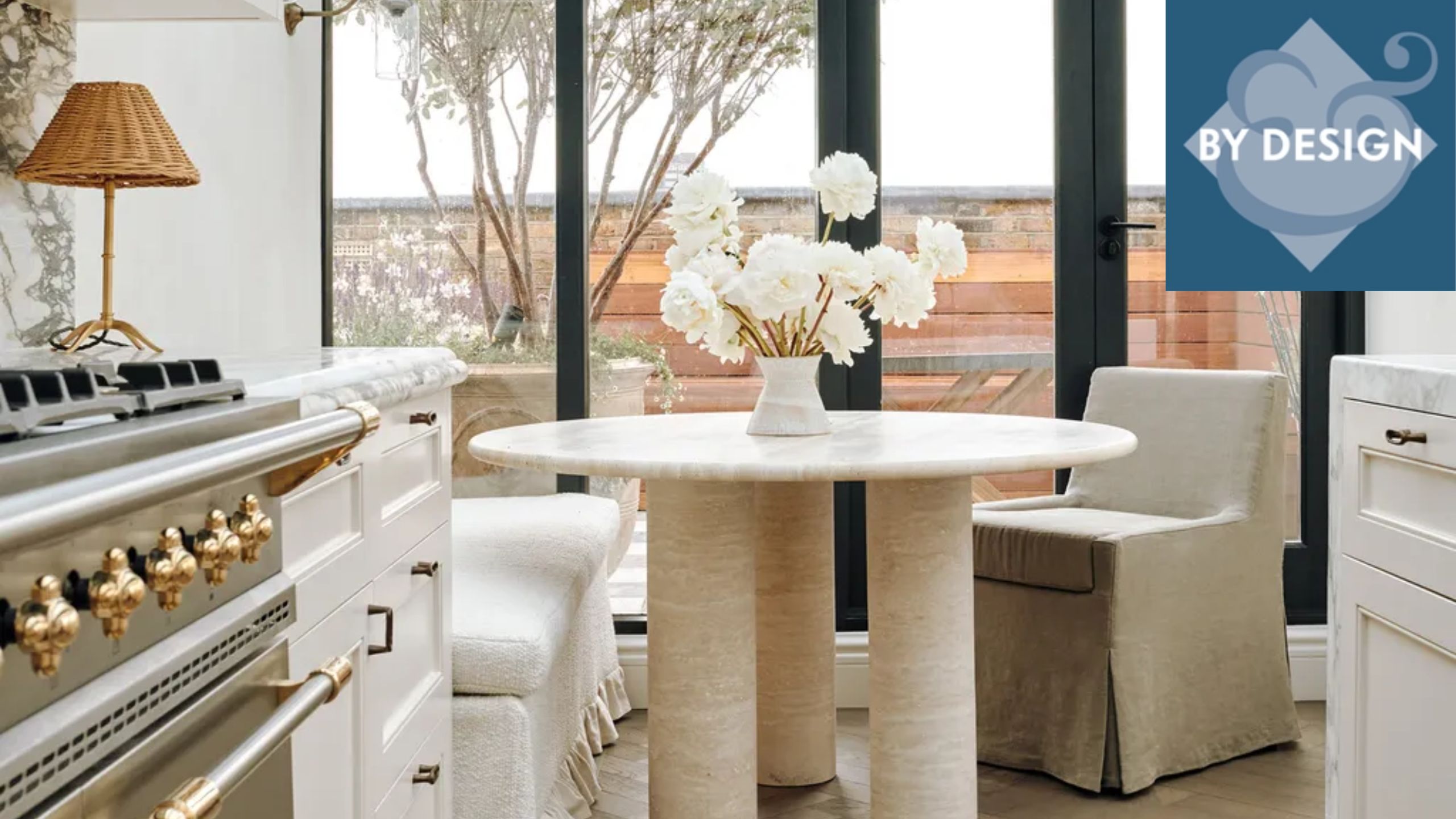 Close up of round dining table in modern kitchen, upholstered seats surround, cooker, countertops in foreground