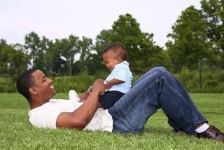 A father and son play in the park.