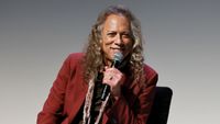 Kirk Hammett smiling and holding a microphone