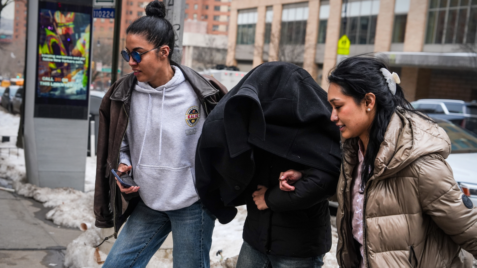 Columbia University neuroscience student Ellie Aghayeva is escorted to her apartment with her face covered, after being detained by federal agents from the Department of Homeland Security.