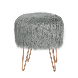 A round gray ottoman with rose gold legs