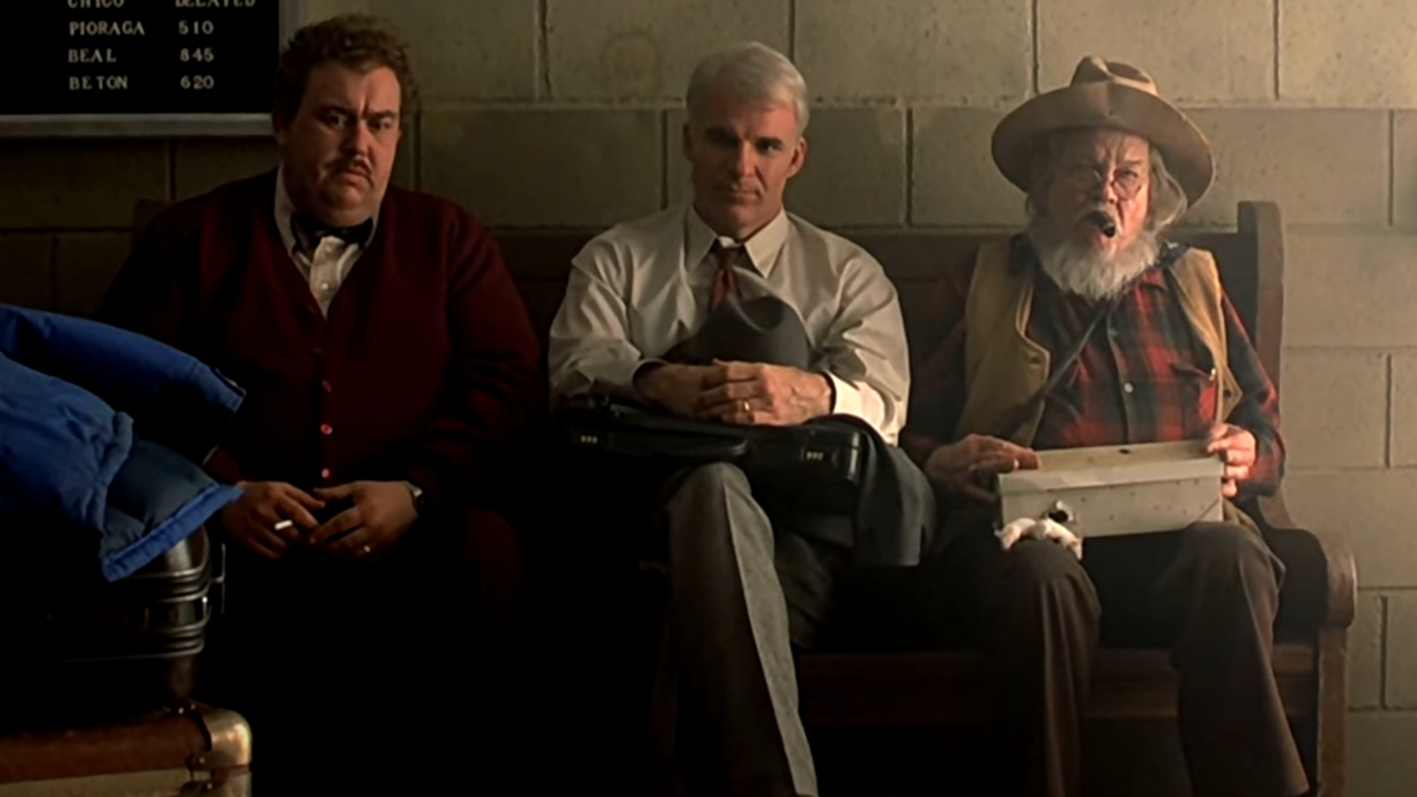John Candy and Steve Martin somberly share a bus bench with an old man in Planes, Trains, and Automobiles.