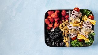 lunch box of healthy snacks on blue background
