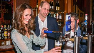 Prince William watches Kate Middleton pull a pint