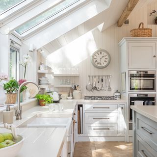 Kitchen extension with side and roof windows, panelled walls and pale blue kitchen units