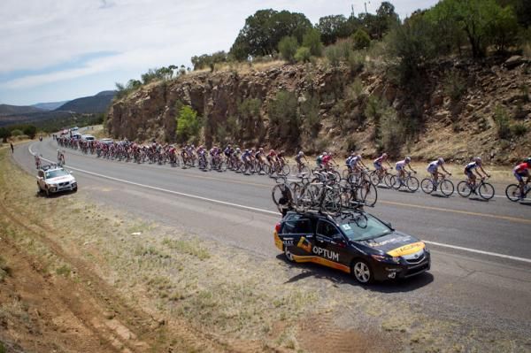 Team cars get pulled away from the break and wait for the main field.