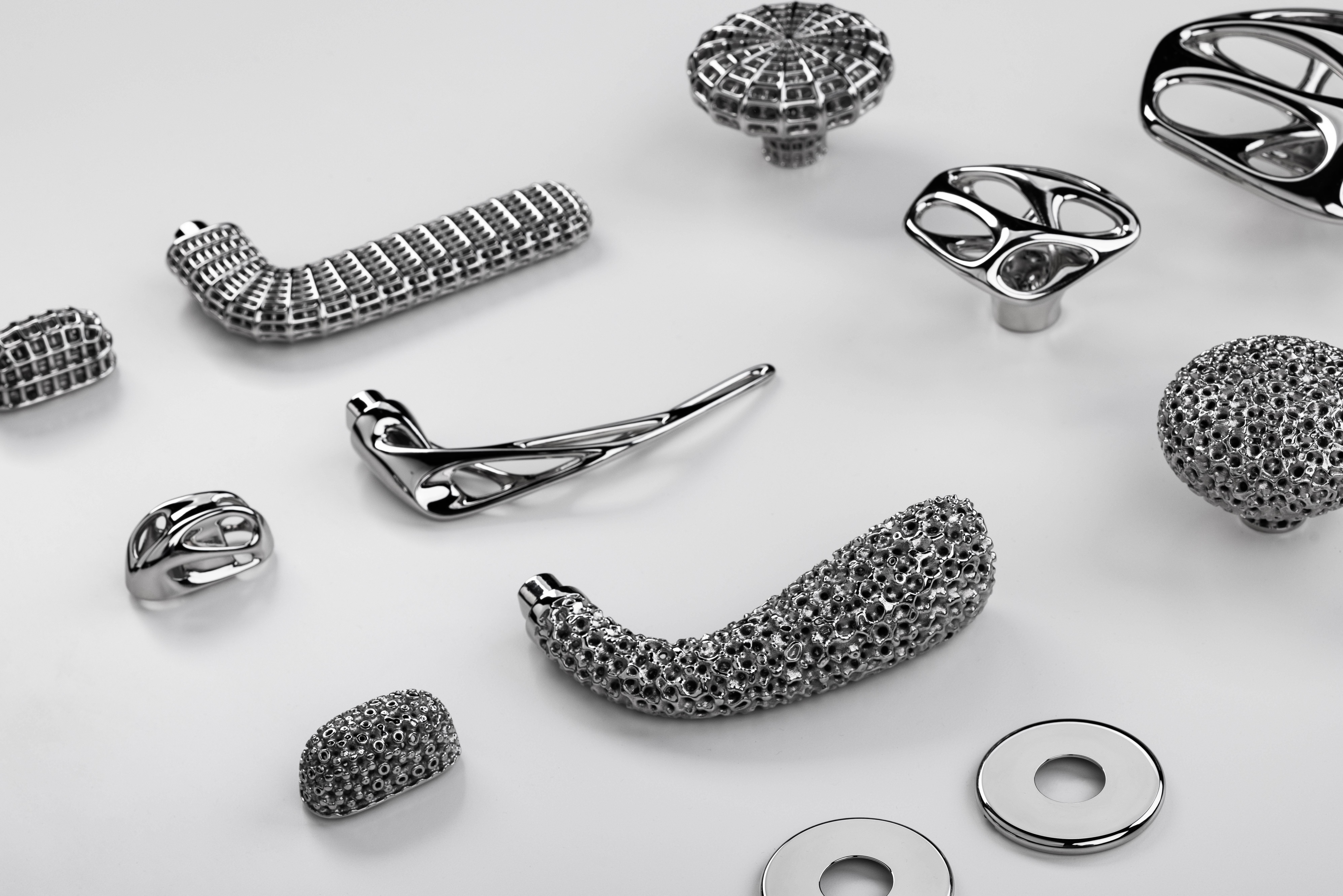 silver handles and knobs laid out on flat, white surface