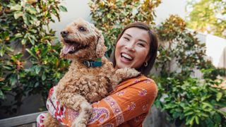 Smiling young Asian woman holding dog