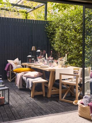 apartment/garden patio idea with outdoor table and chairs, candles, cushions, lanterns