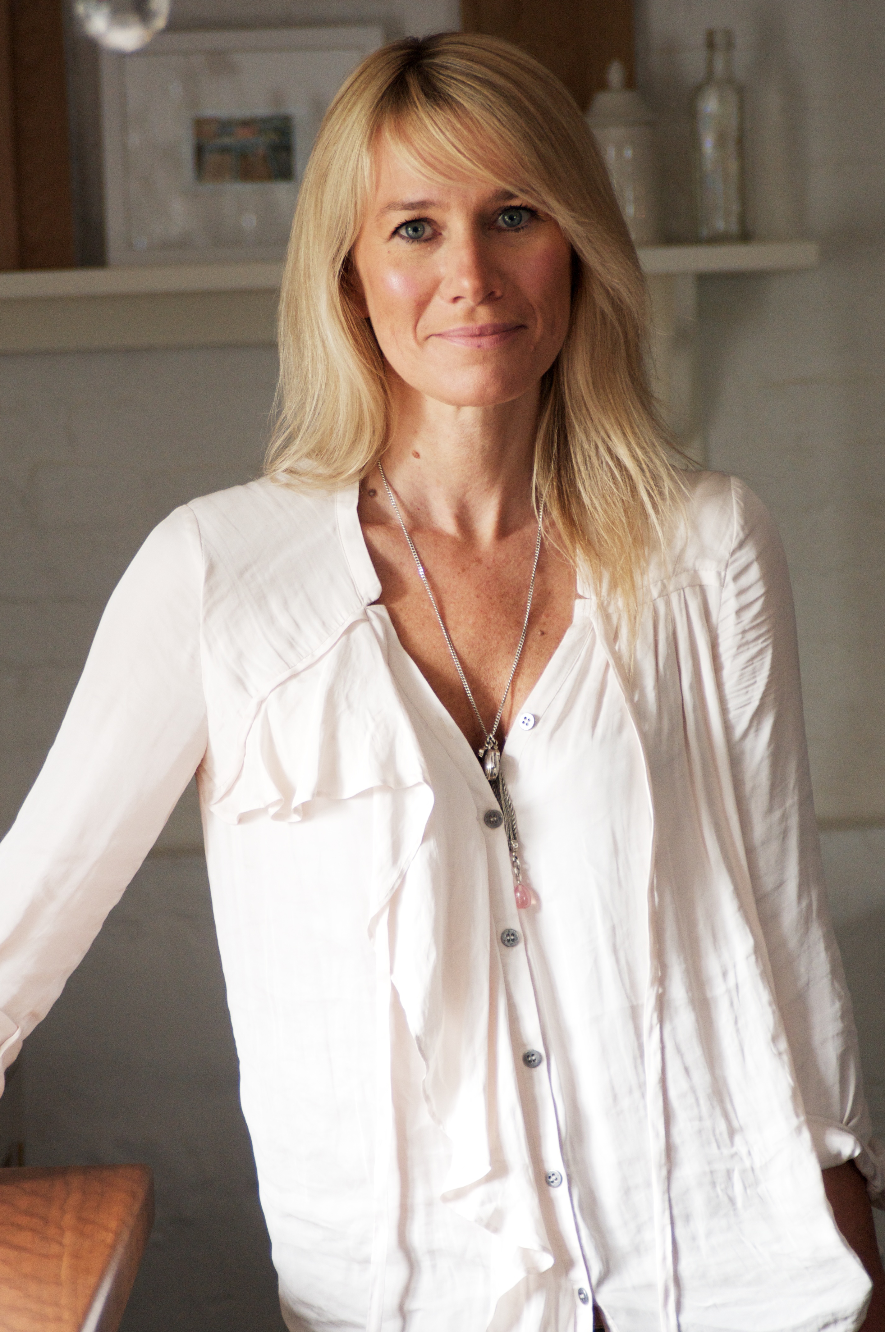 expert headshot of Helen Parker, creative director of deVOL Kitchens, a blond woman standing in a kitchen with a white shirt on 