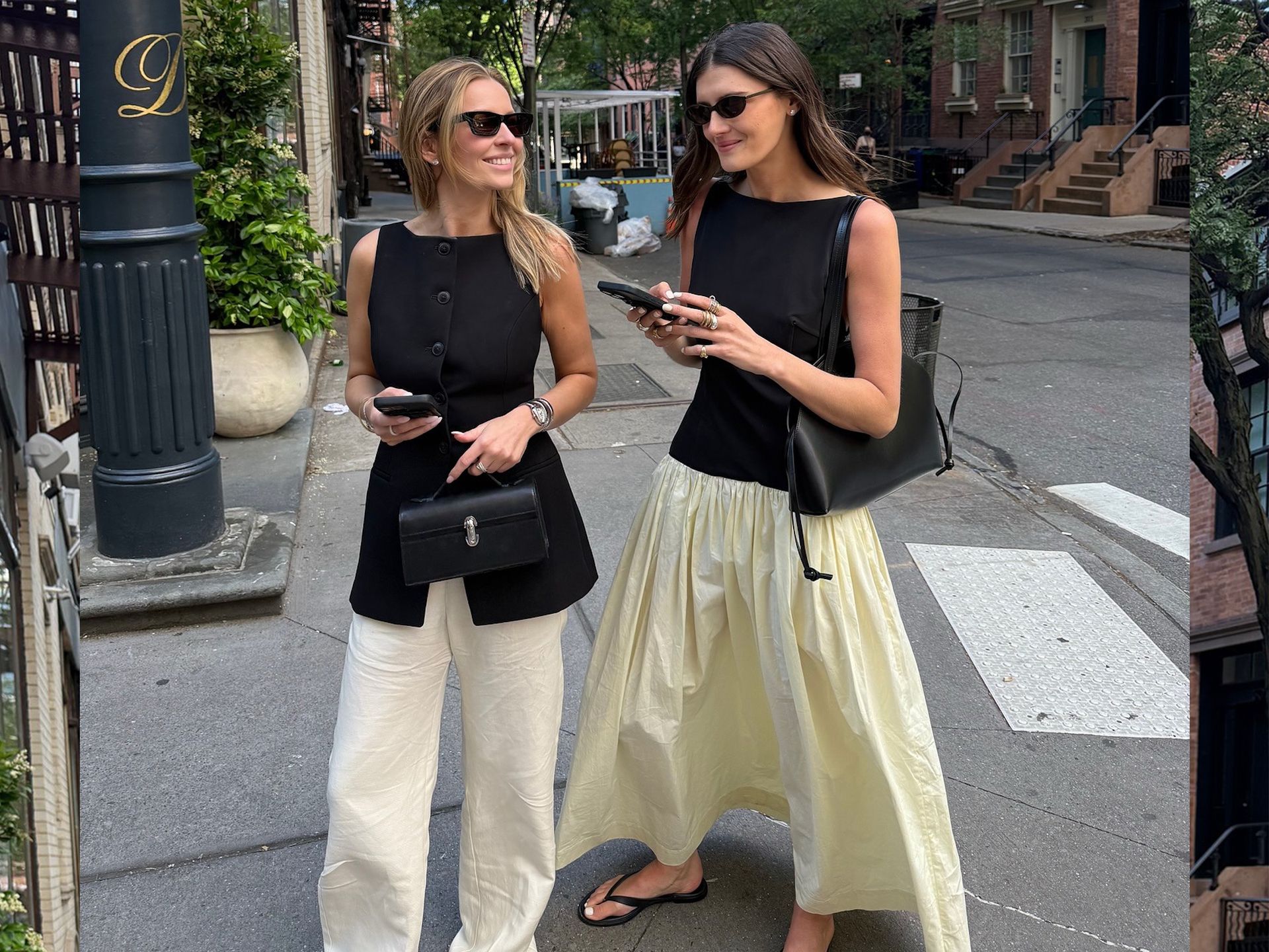 Style influencer Coco Schiffer poses with a friend on a NYC street wearing a contrast dress, black shoulder bag, and flat black flip-flop sandals, while her friend wears a black button-front vest top, black Savette bag, and white linen pants.