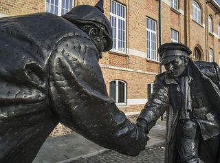 Statue by Andrew Edwards representing British and German soldiers shaking hands during World War One Christmas Truce on the Mesen / Messines market square