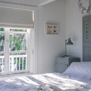 coastal bedroom with white wood panelled walls