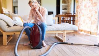 Woman looking over a broken vacuum cleaner