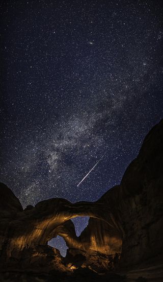 A meteor captured streaking across the sky above Arches National Park, Utah, during the annual Perseid meteor shower. The Perseids is one of the most prolific showers, often with around 80 meteors an hour during its peak. Nevertheless, meteors are hard to catch on camera. The photographer has used an artificial light source to illuminate and emphasise the dramatic rock formations.