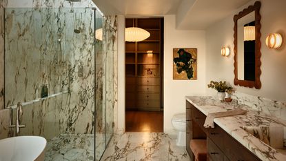 a white marble bathroom with the lights on