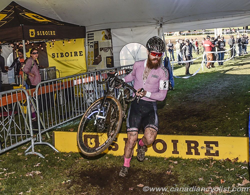 Mark McConnell (Hot Sauce Cycling) over the barriers in the beer tent