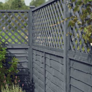 Grey garden fence with top half criss cross