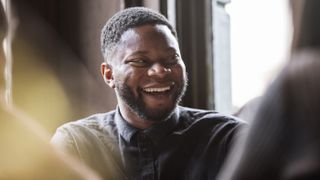 Black man with facial hair in a pub.