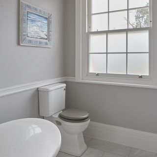 bathroom with photo frame on wall and tiled flooring