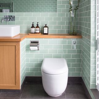 green tiled bathroom with white toilet