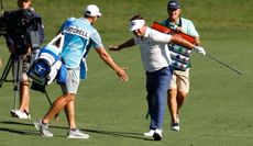 Keith Mitchell high fives his caddie after holing his approach at the 18th green