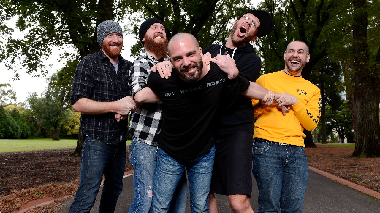 Killswitch Engage laughing and smiling at the camera in a park