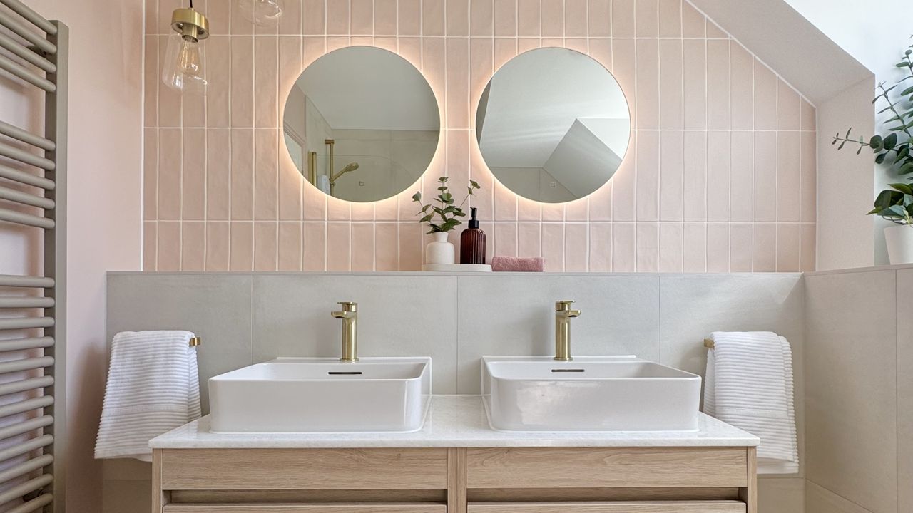 A bathroom with pink zellige tiles and a double vanity with top-mount basins 