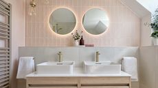 A bathroom with pink zellige tiles and a double vanity with top-mount basins 