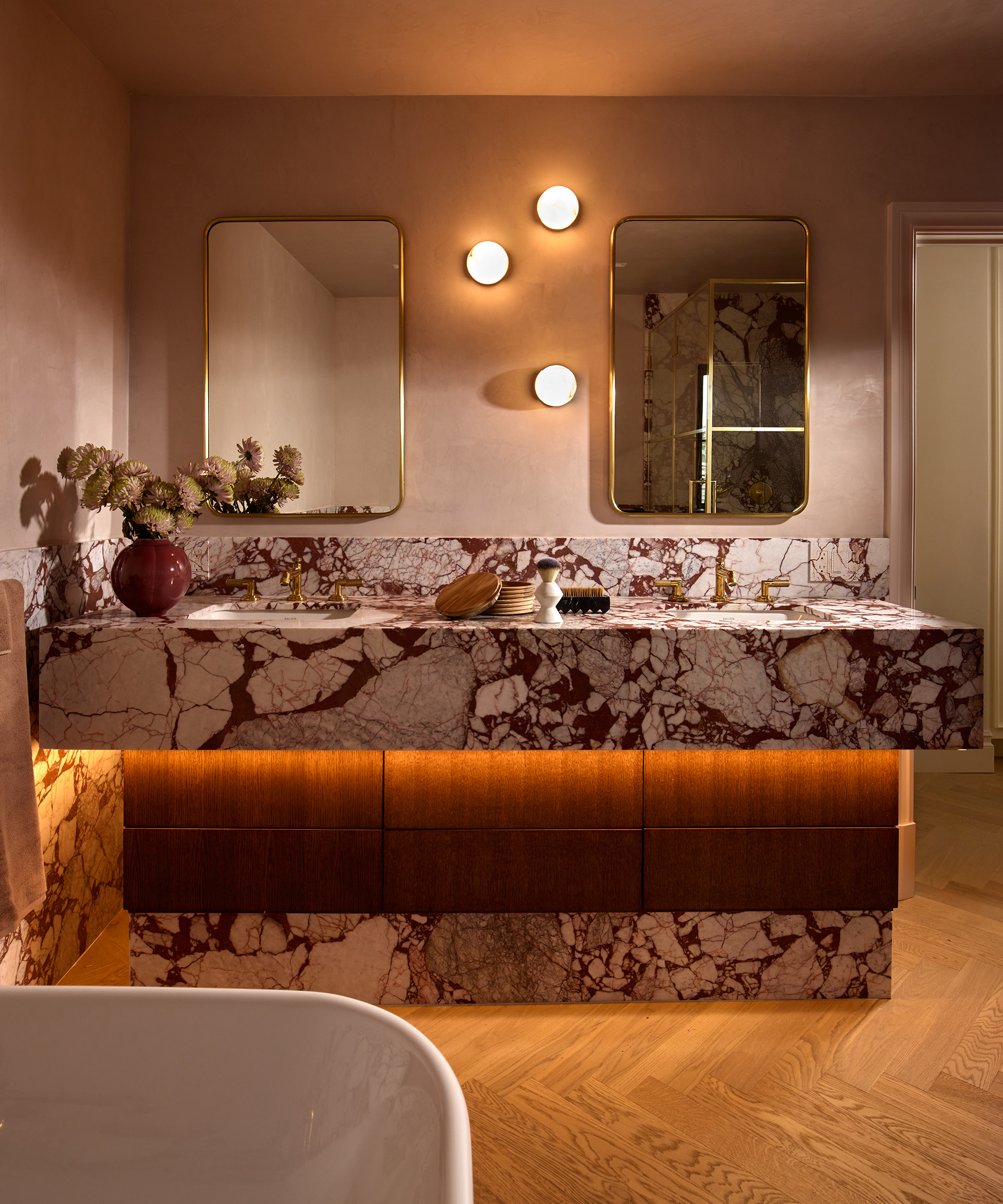 bathroom with marble vanity and three wall lights