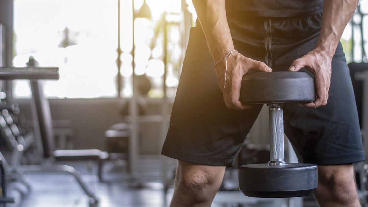 Man grips one end of a dumbbell