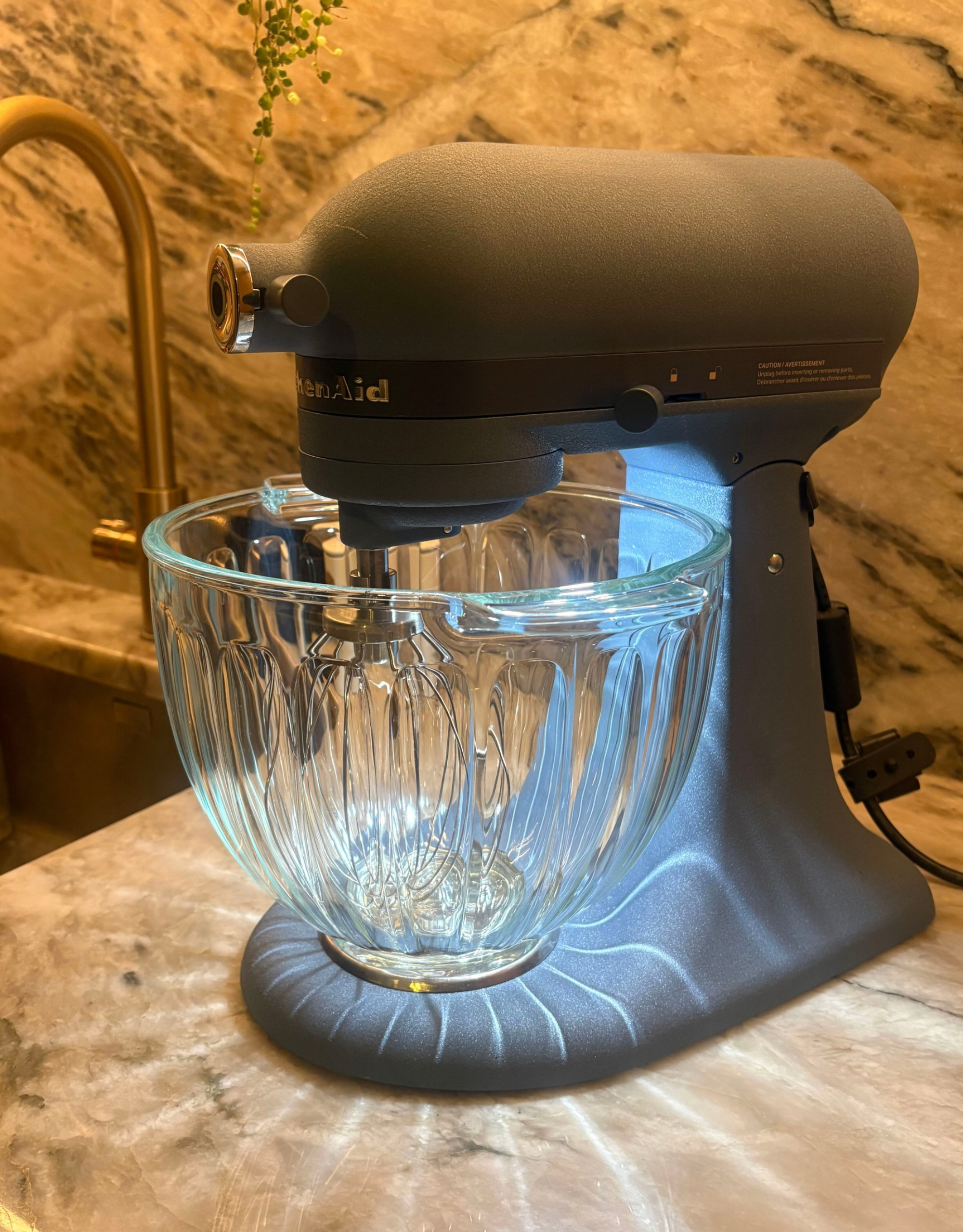 Kitchenaid luminaire casting shadows across a stone countertop