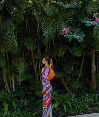 Woman wearing colorful printed swimsuit cover-up maxi dress.