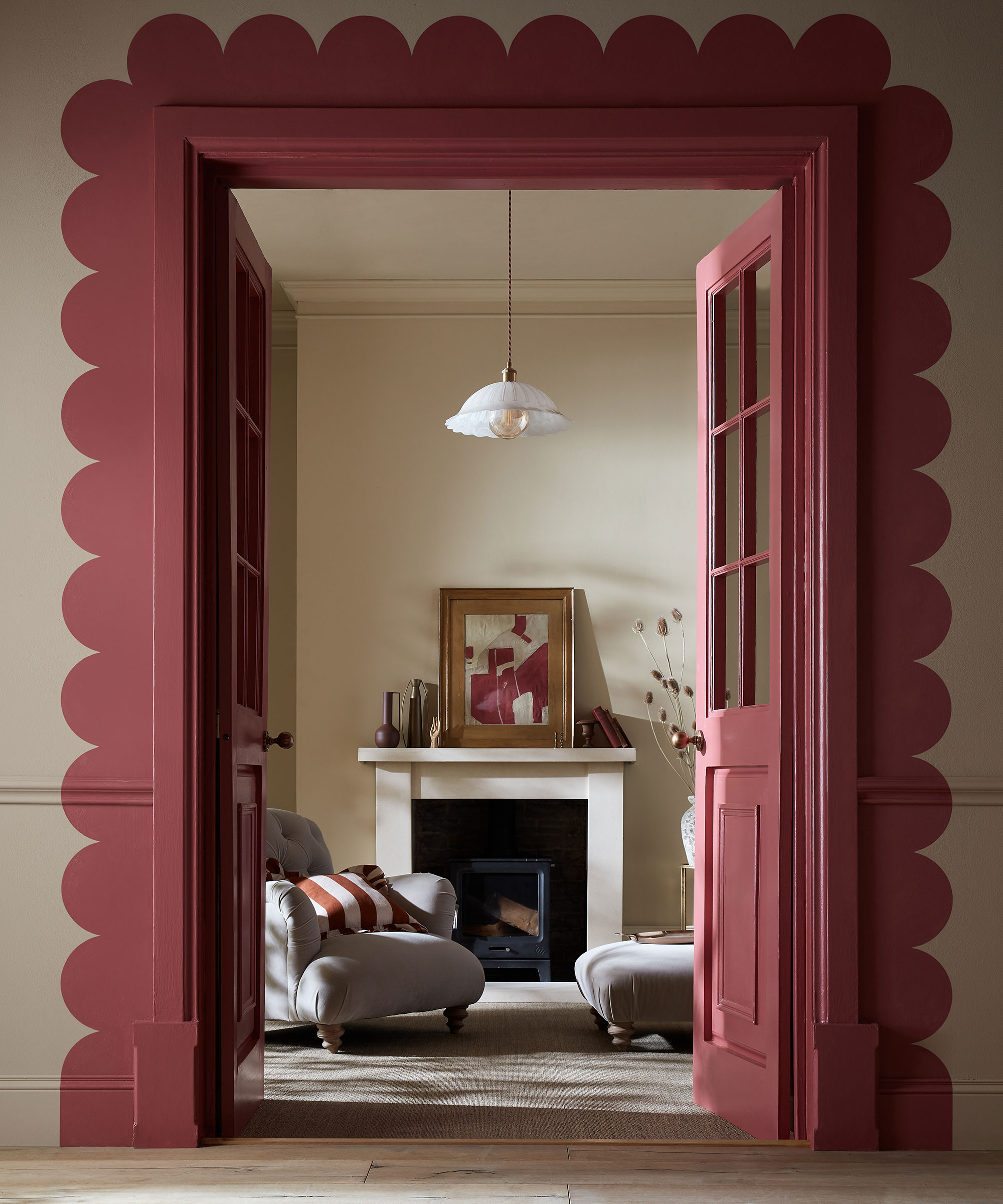 red scalloped paint effect around doorway leading to neutral living room