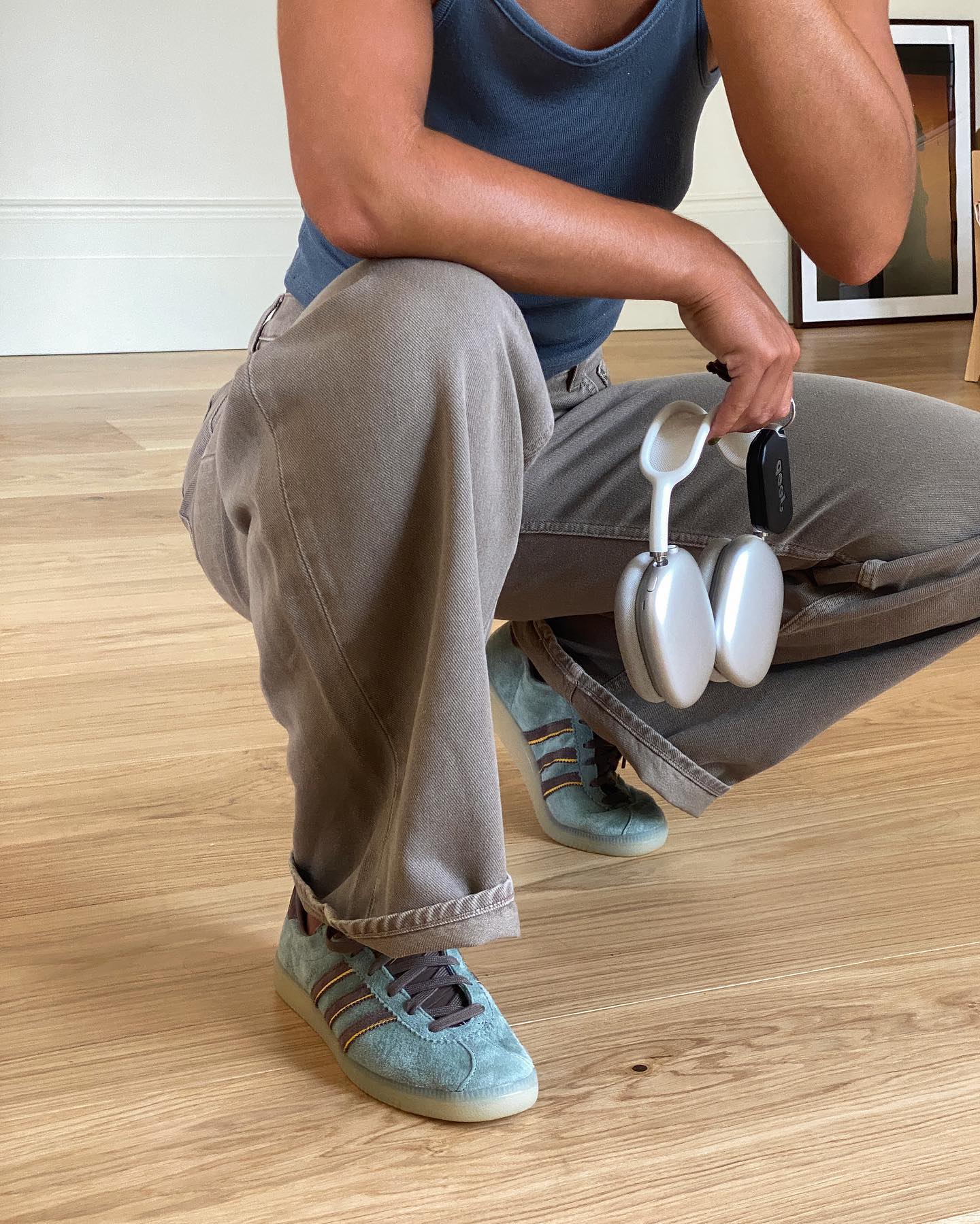 @emwells wears a pair of faded blue trainers with grey jeans