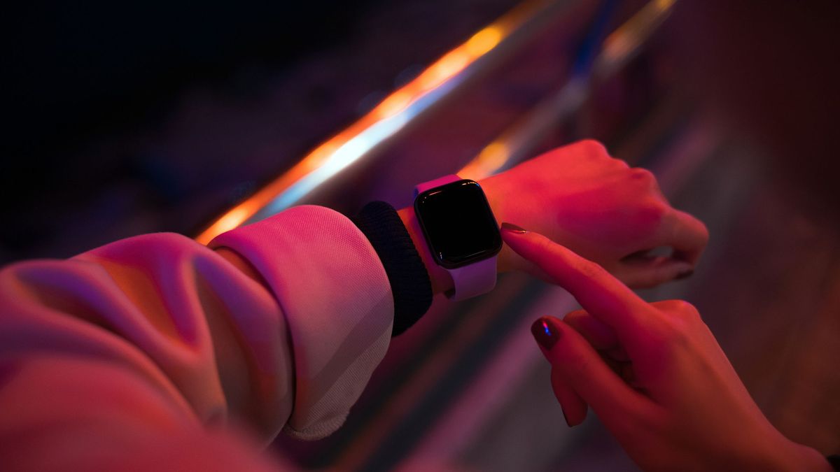 A smartwatch on someone&amp;#039;s arm, lit in red