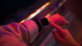 A smartwatch on someone's arm, lit in red
