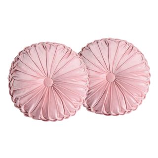 A pair of blush velvet round throw pillows