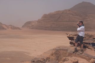 Virtual cinematography; a man stands on a rock in a desert