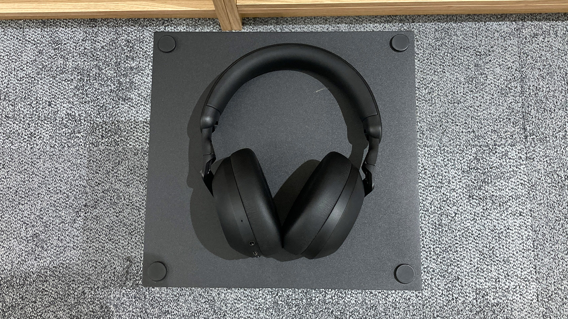 Philips TAH8000E wireless over-ear headphones on black table above grey carpet